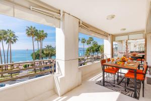 a balcony with a table and chairs and a view of the ocean at 67 Croisette YourHostHelper in Cannes