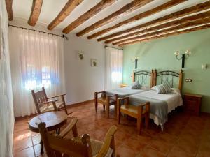 a bedroom with two beds and a table and chairs at Caserón De La Fuente in Albarracín