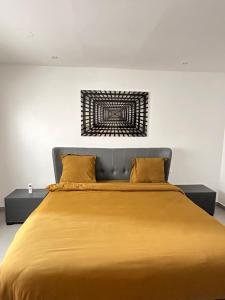 a bedroom with a large bed with yellow pillows at DUPLEX VIRAGE in Dakar