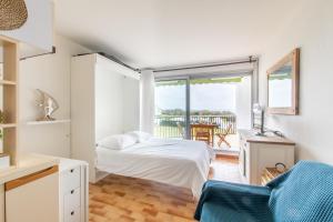 een slaapkamer met een bed en een balkon met een tafel bij Les dunes * parking privé * piscine * Aperçue mer in La Grande-Motte