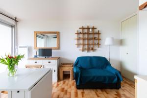 a living room with a blue chair and a table at Les dunes * parking privé * piscine * Aperçue mer in La Grande-Motte