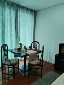 a dining room with a table and chairs and a television at Suíte com varanda e vista de mar in Valadares +29 photos