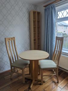 a table and two chairs and a table and a window at Rooms close to City Centre in Beeston Hill