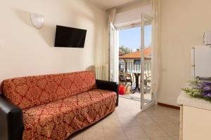 a living room with a couch and a television at Residence Uno Studio&Suites in Rimini