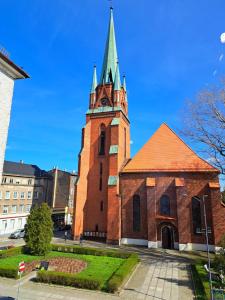 een kerk met een toren met een klok erop bij Apartament Nova in Racibórz