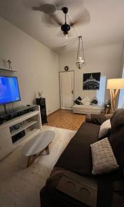 sala de estar con sofá y TV de pantalla plana en APTO KING - 5 mins a pé da Praia do Forte, en Cabo Frío