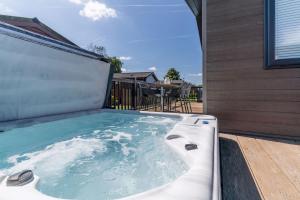 a hot tub on the deck of a house at Roydon Marina - Lodge 1 - Hot Tub in Roydon