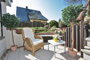 a wicker chair and a table on a patio at Haus König Ferienwohnung 1 und 2 in Lichtenhain