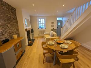 a kitchen and living room with a table and chairs at Merywen Cottage in Conwy