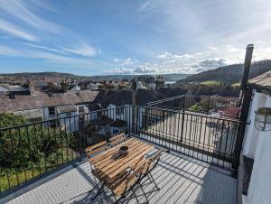 a balcony with a wooden bench on top of a building at Merywen Cottage in Conwy