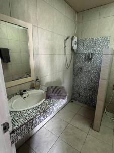 a bathroom with a bath tub and a shower at Beach house steps from the sea in Ban Bang Po