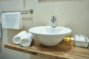 a bathroom sink on a wooden counter with towels at Charma Residence in Sibiu