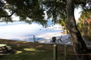 a beach with chairs and people in the water at Beautiful Condo-Studio in Fort Walton Beach in Fort Walton Beach +2 photos