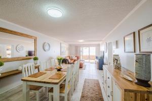 cocina y comedor con mesa y sillas en Jeffreys Bay Beach Accommodation en Jeffreys Bay