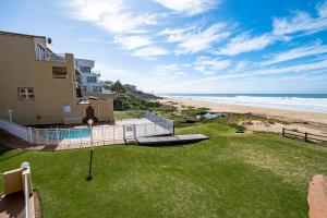 un apartamento en condominio con vistas a la playa desde el balcón en Jeffreys Bay Beach Accommodation, en Jeffreys Bay