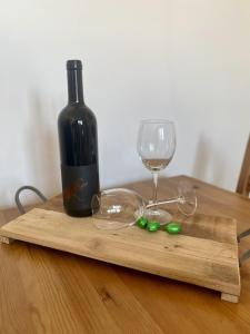 a wooden cutting board with a bottle of wine and a glass at City Retreat in Eisenstadt Zentrum in Eisenstadt
