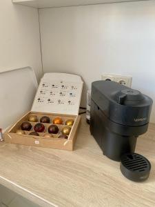 a box of donuts next to a coffee maker at City Retreat in Eisenstadt Zentrum in Eisenstadt