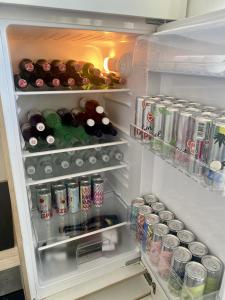 an open refrigerator filled with drinks and soda cans at City Retreat in Eisenstadt Zentrum in Eisenstadt