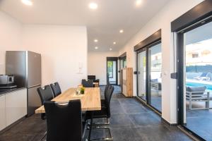 a kitchen and dining room with a wooden table and chairs at Villa Gräfin in Malinska