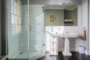 a bathroom with a glass shower and a sink at Large Central 5 Bed House with Stunning Gardens! in Cheltenham