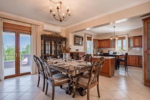 a kitchen and dining room with a table and chairs at Villa Aris: A Serene Experience, 3BRs, Pool & Bbq in Magnisía