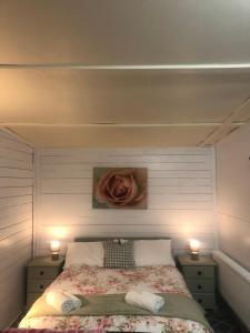 a bedroom with a bed with a rose on the wall at Bob’s Cabin in Galway