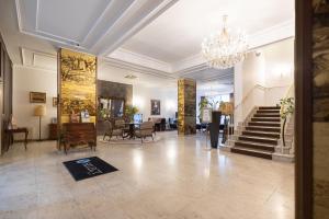 eine Lobby mit einer Treppe und einem Kronleuchter in der Unterkunft Select Hotel Prinz Eugen Wien in Wien