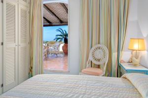 a bedroom with a bed and a chair and a patio at Terrazza sul mare a Porto Cervo in Porto Cervo