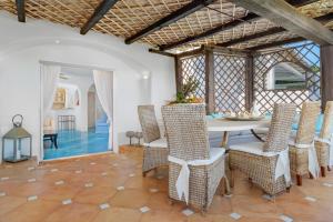 - une salle à manger avec une table et des chaises dans l'établissement Terrazza sul mare a Porto Cervo, à Porto Cervo