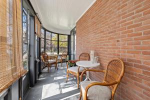 een patio met stoelen en tafels en een bakstenen muur bij Merlot on Mary in Picton