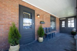 a brick building with a door and a bench and plants at Merlot on Mary in Picton