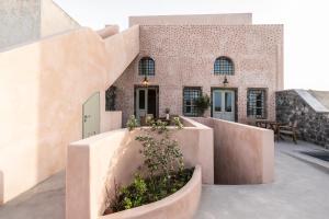 a house with a courtyard in front of a building at Frescoes Luxury Suites in Mesaria