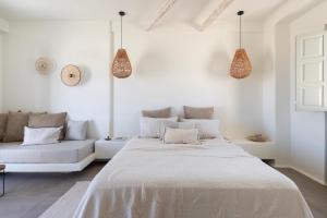 una camera bianca con un letto e un divano di Frescoes Luxury Suites a Mesariá