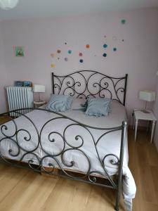 a bedroom with a metal bed with two pillows at Maison De Village in Barbechat