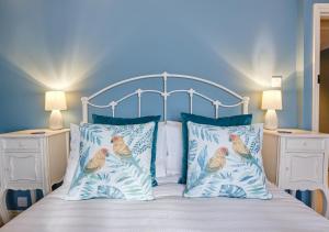 a bedroom with a bed with two pillows with birds on it at Rose Cottage - North Elmham in North Elmham