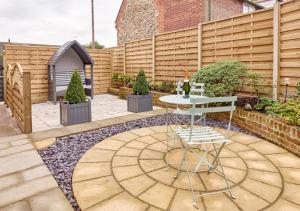a patio with a table and a fence at Rose Cottage - North Elmham in North Elmham