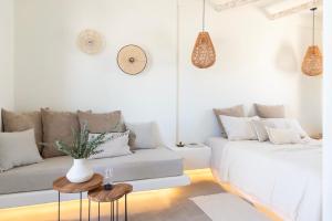 un soggiorno bianco con divano e tavolo di Frescoes Luxury Suites a Mesariá