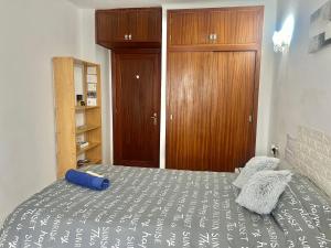 1 dormitorio con 1 cama y armario de madera en Habitacion LUMINOSA en Palma para una sola persona en casa familiar, en Palma de Mallorca