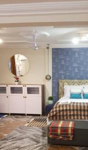 um quarto com uma cama e uma parede azul em Nana Adu Guest House em Koforidua