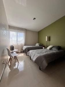 a large bedroom with two beds and a desk at Casa Bon es una propiedad completa al sur de la ciudad que te ofrece modernidad, espacio, tranquilidad, cuenta con 4 recamaras 3 baños completos y 2 cajones de estacionamiento privados in Guadalajara