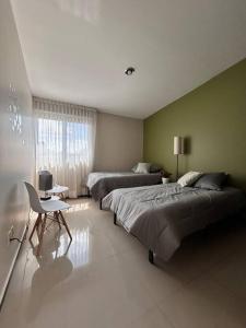 a large bedroom with two beds and a desk at Nueva Galicia residencial, es una propiedad completa al sur de la ciudad que te ofrece modernidad, espacio, tranquilidad, cuenta con 4 recamaras 3 baños completos y 2 cajones de estacionamiento privados in Guadalajara +51 photos