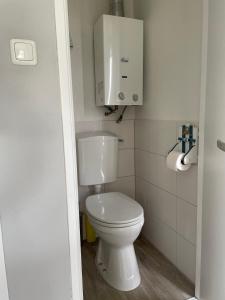 baño con aseo blanco y dispensador de papel en Luxe chalet Friesland - 5 pers, en Westergeest