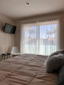a bedroom with a large bed with a large window at Casa Bon es una propiedad completa al sur de la ciudad que te ofrece modernidad, espacio, tranquilidad, cuenta con 4 recamaras 3 baños completos y 2 cajones de estacionamiento privados in Guadalajara