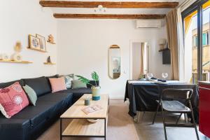 a living room with a black couch and a table at Lodging Apartments Almirall Beach 51 in Barcelona