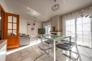 ein Wohnzimmer mit einem Glastisch und Stühlen in der Unterkunft Villa Puerto Blanquillo in Frigiliana