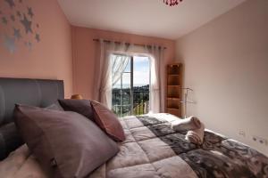 ein Schlafzimmer mit einem Bett mit Kissen und einem Fenster in der Unterkunft Villa Puerto Blanquillo in Frigiliana + 26 Fotos