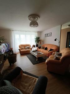 a living room with couches and a table at Maison De Village in Barbechat