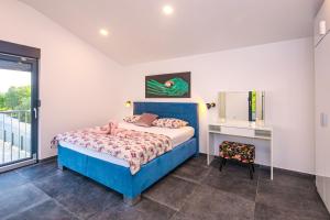 a bedroom with a blue bed and a desk at Villa Gräfin in Malinska +47 photos