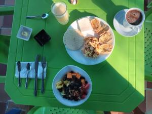 einen grünen Tisch mit zwei Teller Essen und einer Schüssel Brot in der Unterkunft Cabaña RECUERDO Lodge, B & B in Moñitos