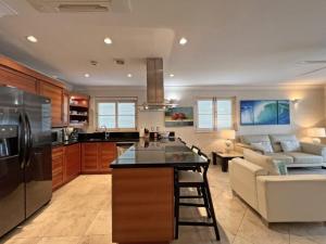 a kitchen and living room with a refrigerator and a couch at Waterside Apartment 101 by Island Villas in Saint James